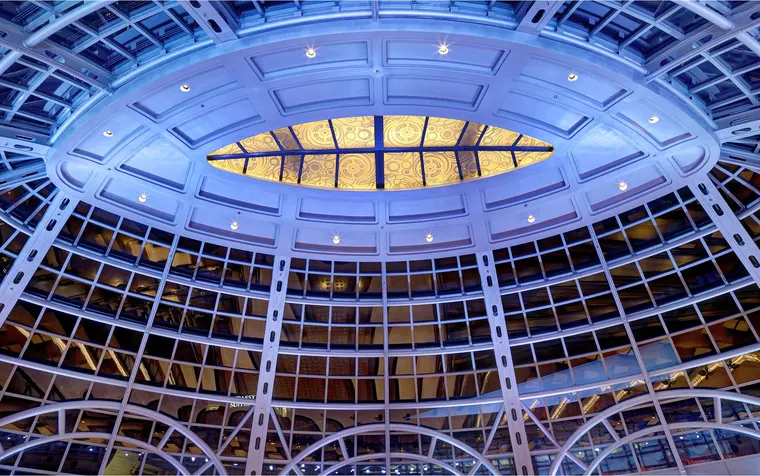 Blue-lit glass rotunda of Fallsview Casino Resort at night